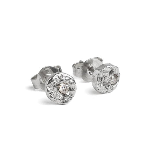 Silver stud earrings with an organic texture and a white moissanite diamond