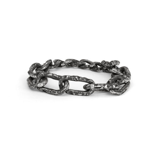 Silver chain bracelet with big links and a raw texture on a white background