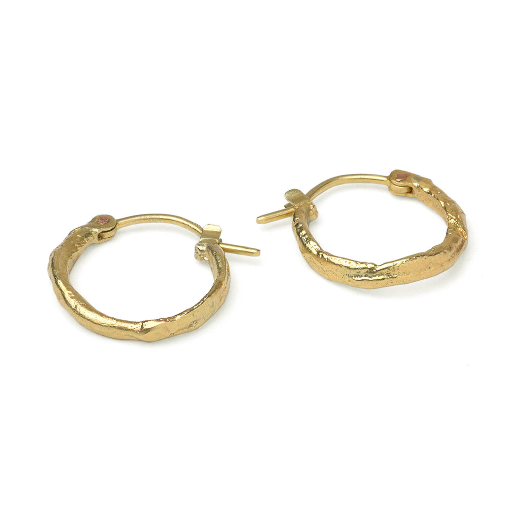 Yellow gold hoop earrings with a molton texture, handcrafted in Berlin on a white background.