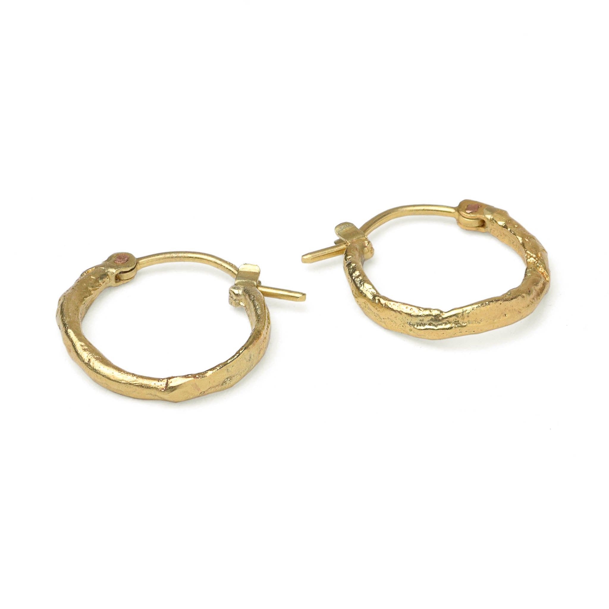 Yellow gold hoop earrings with a molton texture, handcrafted in Berlin on a white background.