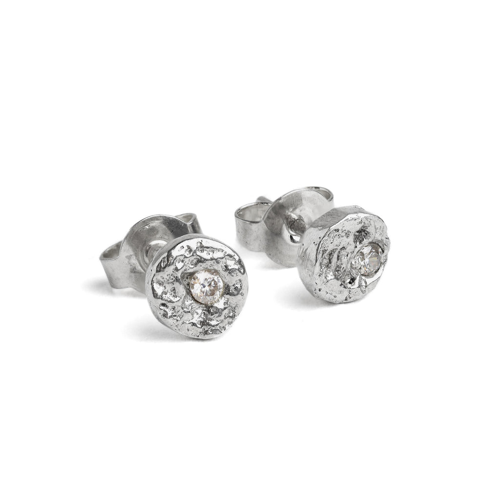 Handcrafted sterling silver disc stud earrings set with brilliant cut moissanites and a natural cast finish.