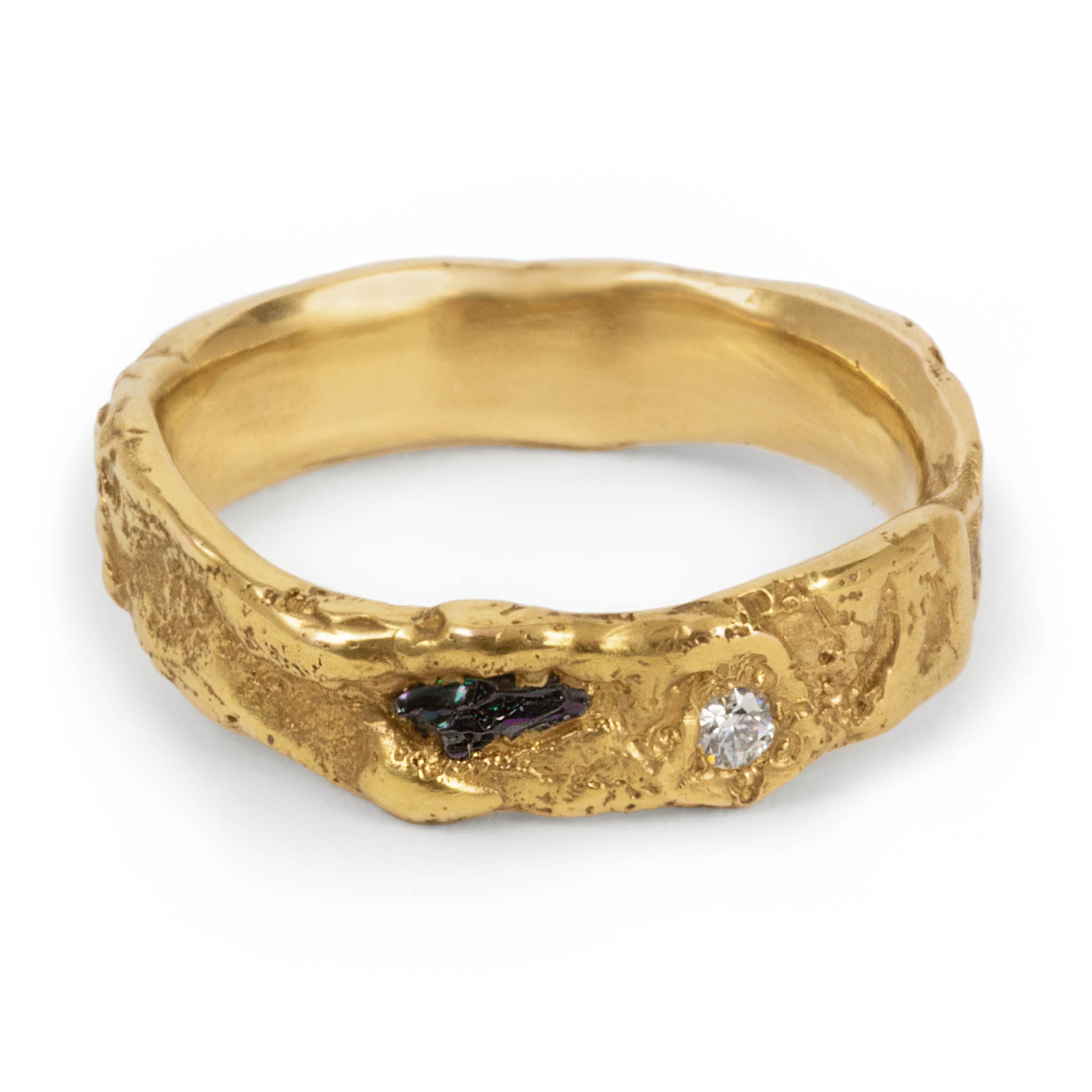 Handcrafted gold ring with raw black moissanite and clear faceted moissanite set in an organic textured 4 mm band, made in Berlin studio.