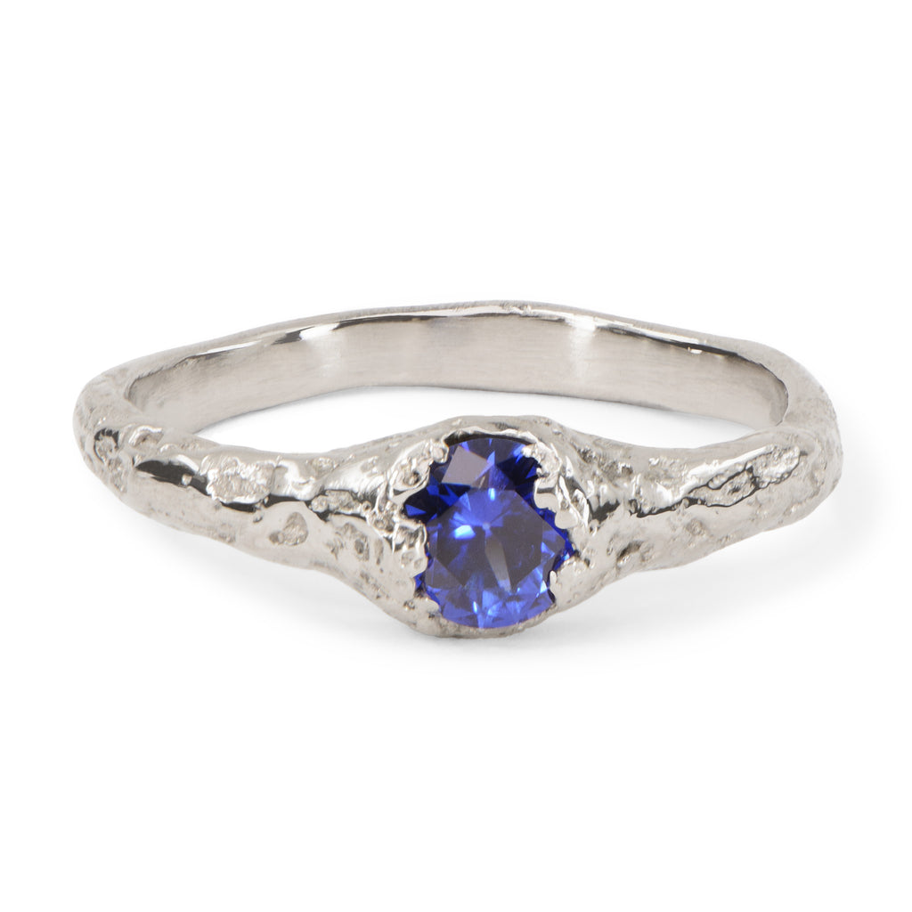 Handcrafted organic white gold engagement ring set with a blue sapphire.