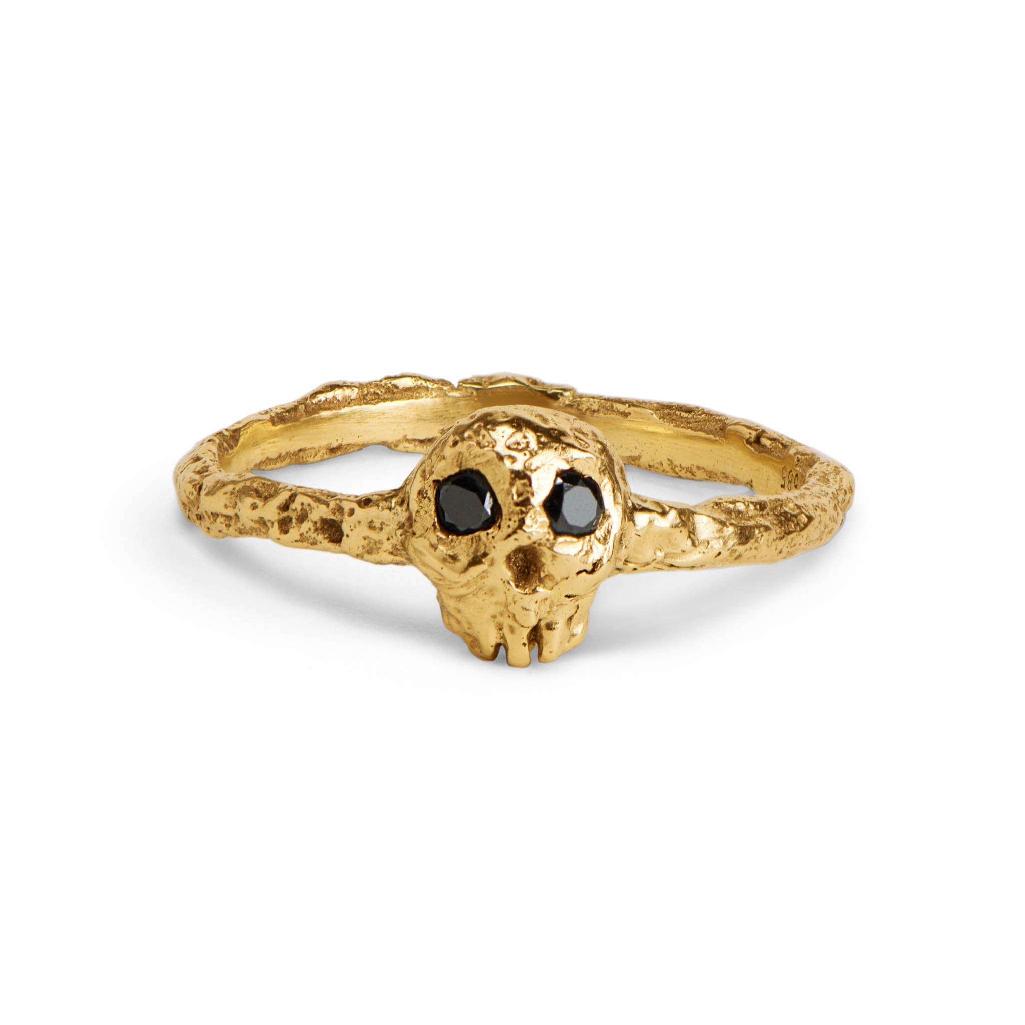 Gold skull ring with black gemstones on a white background