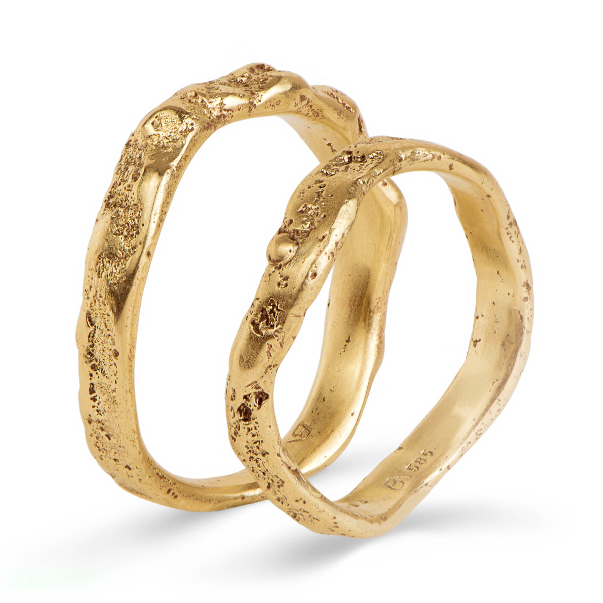 Two gold wedding rings with a textured surface on a white background
