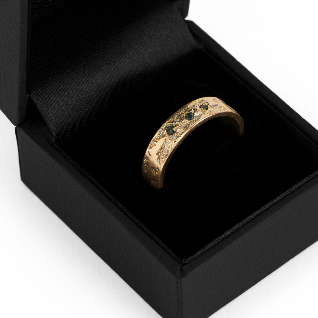 The Sabik ring in yellow gold with three tourmalines in a black Luxury Jewelry box.
