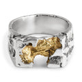 Sculptural sterling silver signet ring with gold plated center laying on a white background.
