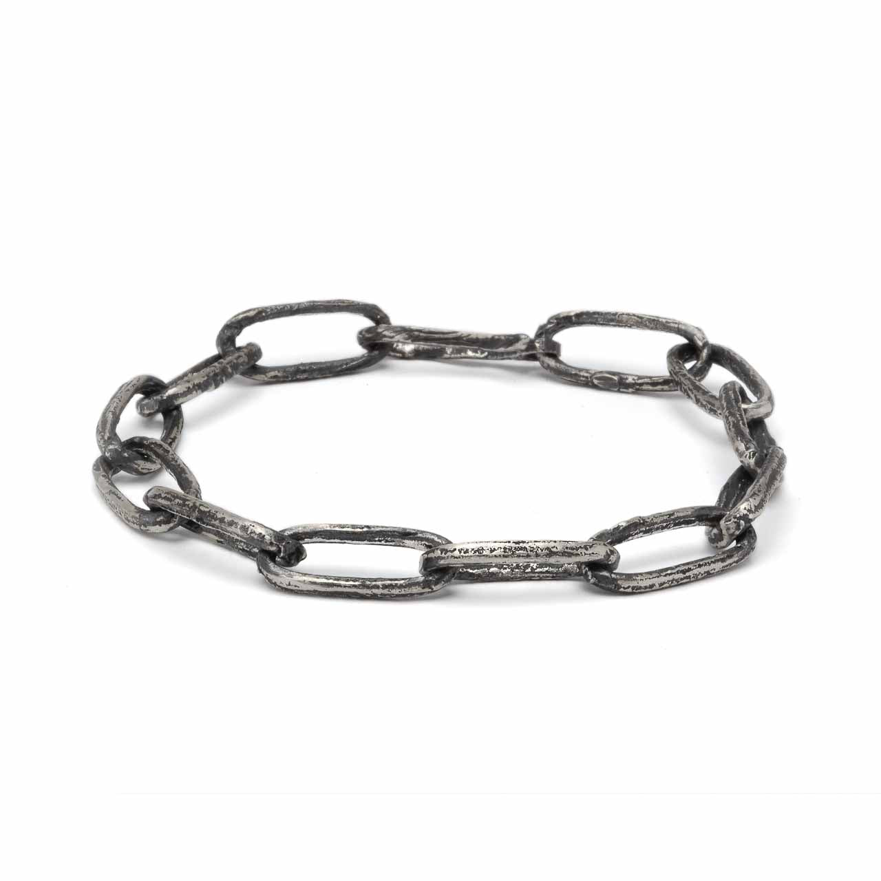 Handcrafted sterling silver link bracelet oxidised to highlight its handmade quality on a white background.
