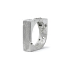 Handcrafted sterling silver ring with sculpted 8 mm wide band featuring textured and polished contrasts standing on a white background.