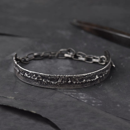 Mens Bracelet in Sterling Silver, laying on a dark surface with some goldsmiths tools
