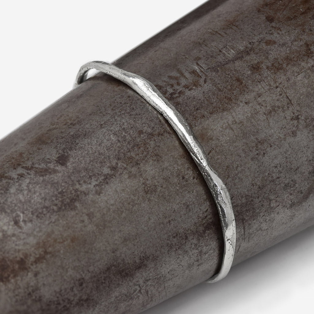 Close Up of our Dingolay bracelet showing its sandy texture and flowing shape on a wrist shaped object.