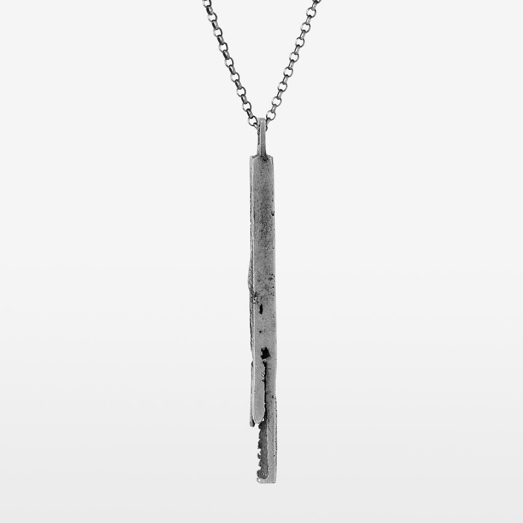 Handcrafted sterling silver bar pendant with a subtle vertical fissure suspended from a sterling silver chain on a white background.