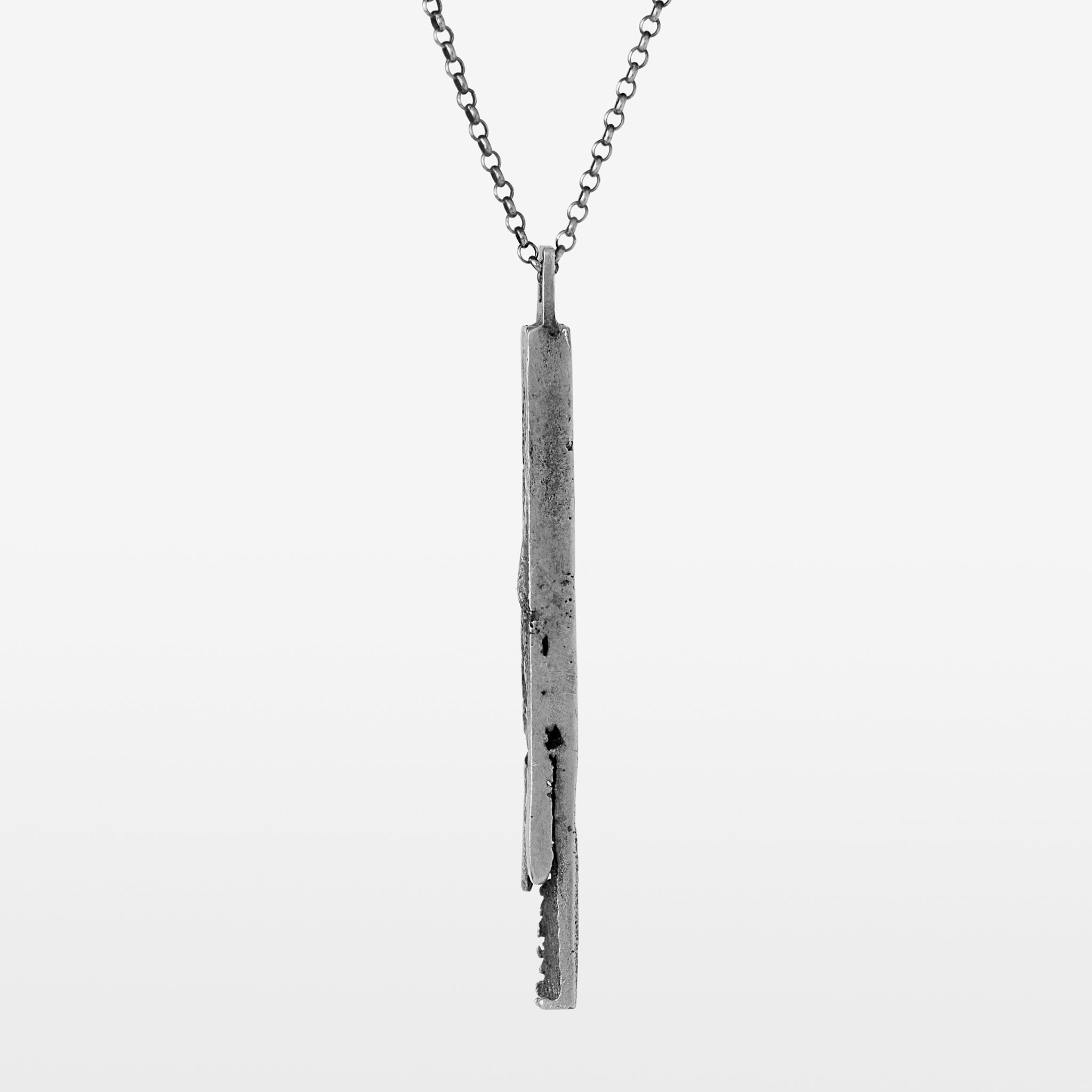 Handcrafted sterling silver bar pendant with a subtle vertical fissure suspended from a sterling silver chain on a white background.