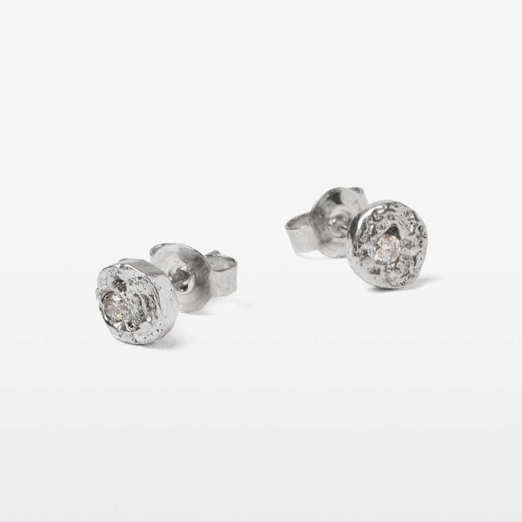 Handcrafted sterling silver disc stud earrings set with brilliant cut moissanites and a natural cast finish.