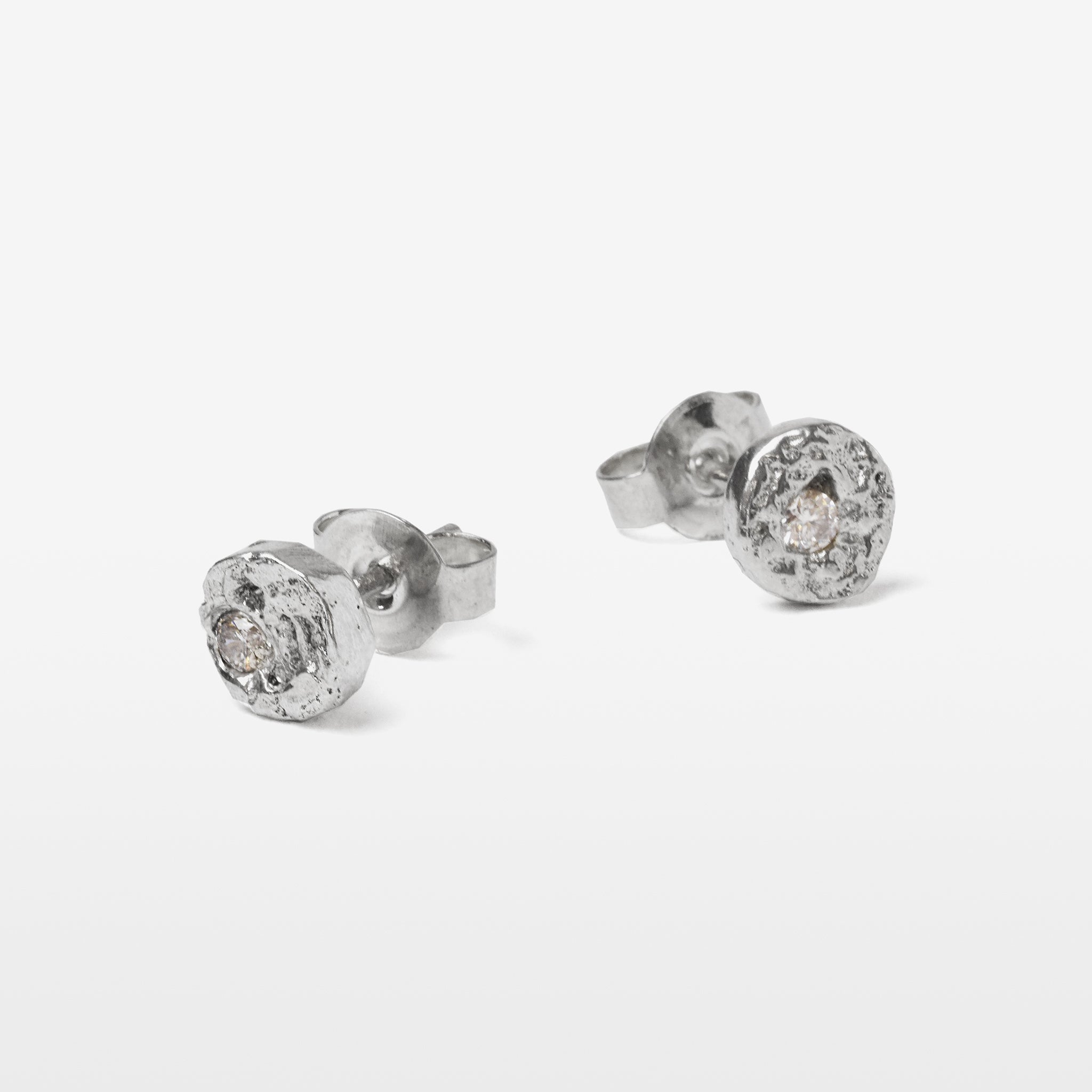 Handcrafted sterling silver disc stud earrings set with brilliant cut moissanites and a natural cast finish.