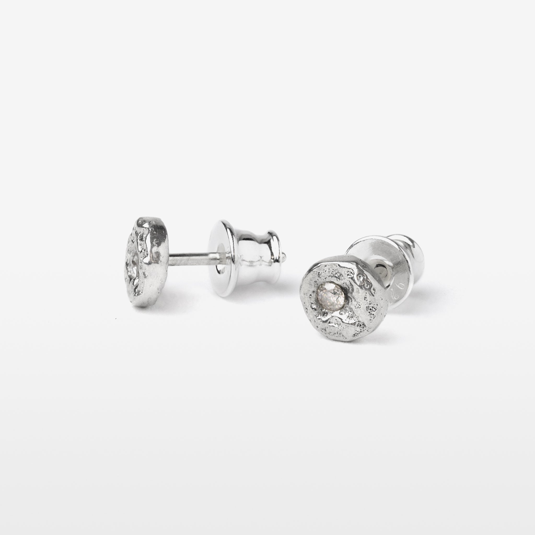 Handcrafted sterling silver disc stud earrings set with brilliant cut moissanites and a natural cast finish.