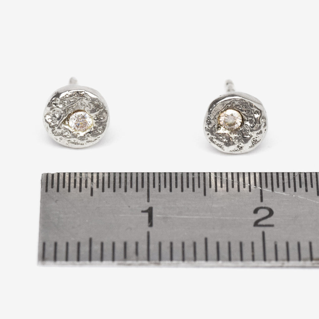 Handcrafted sterling silver disc stud earrings set with brilliant cut moissanites and a natural cast finish.