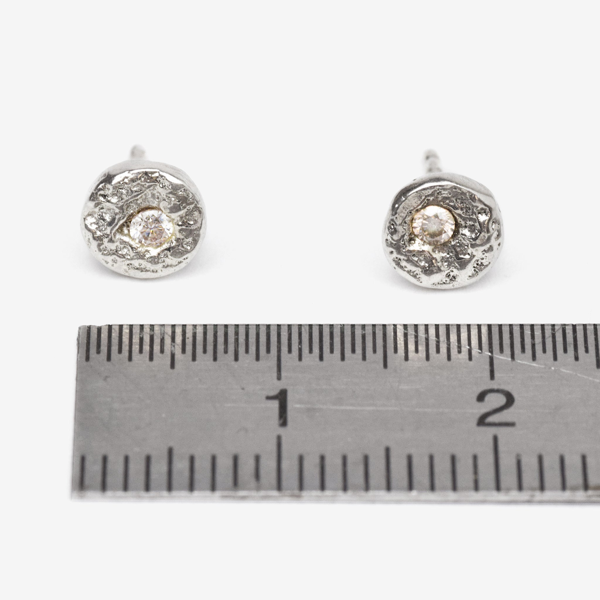 Handcrafted sterling silver disc stud earrings set with brilliant cut moissanites and a natural cast finish.