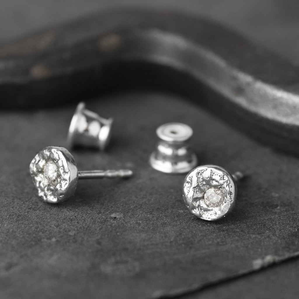 Handcrafted sterling silver disc stud earrings set with brilliant cut moissanites and a natural cast finish.