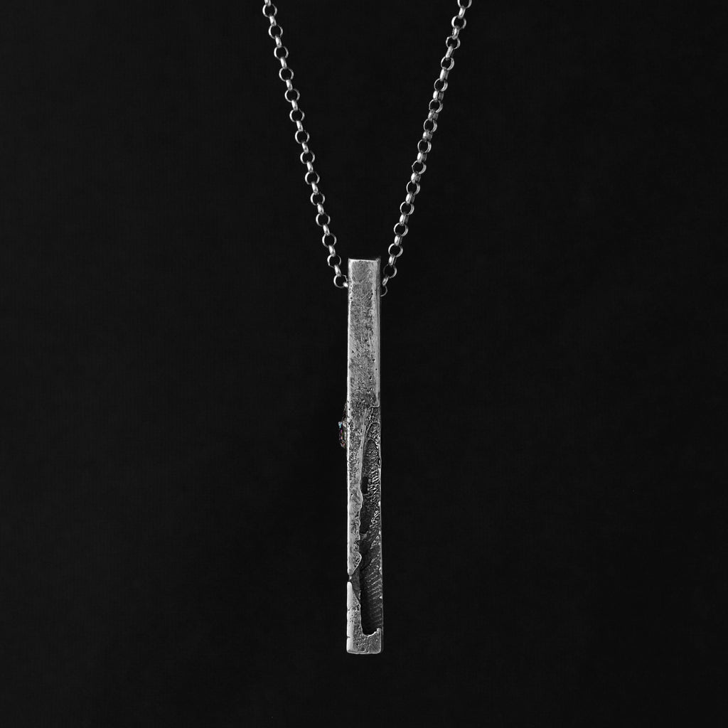 Textured silver monolith pendant gainst a blöack background