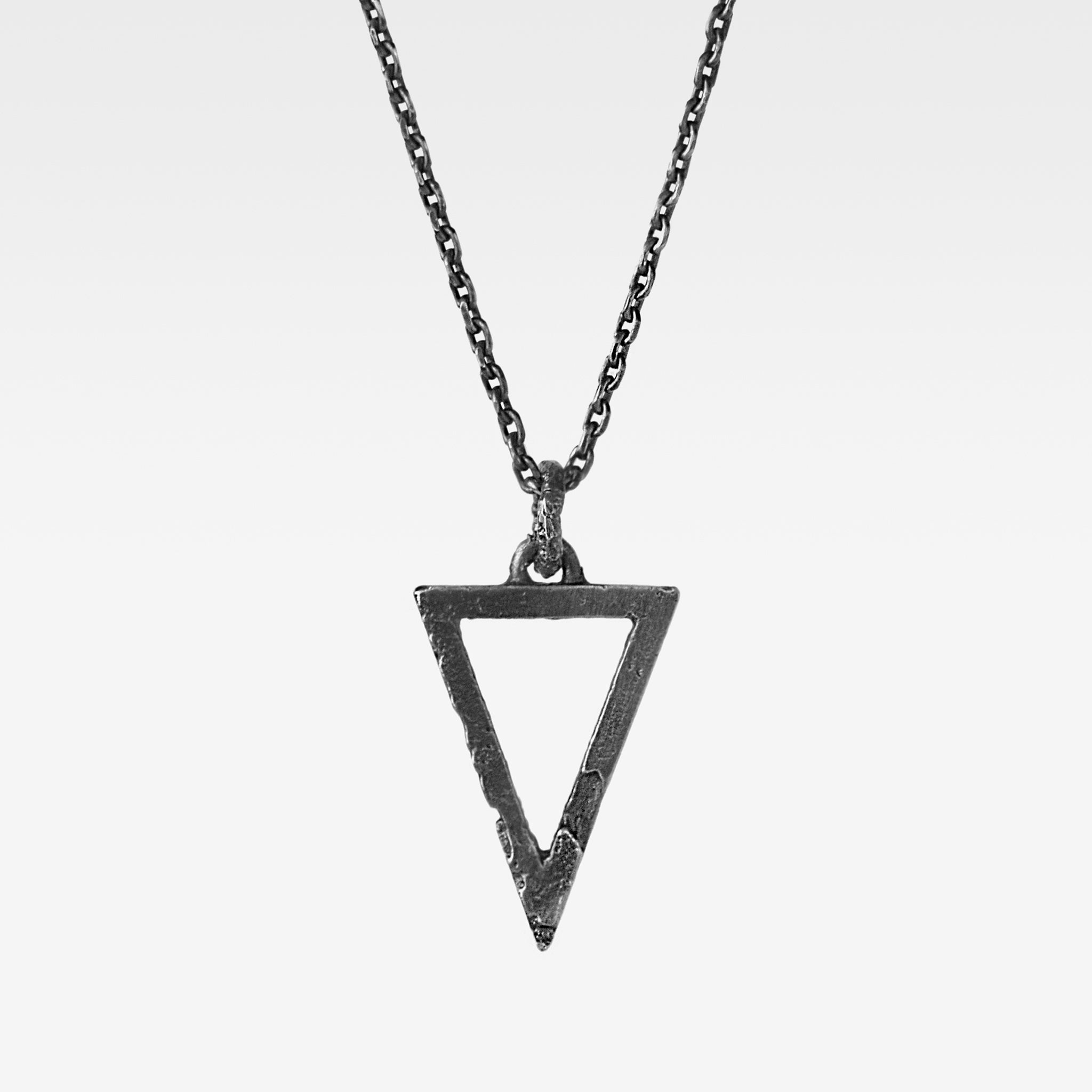 Alternative sterling silver triangle pendant with an raw textured finish suspended from a sterling silver chain. 